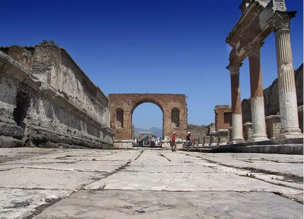 A head on view of an archway that forms part of the ruins of Pompeii.