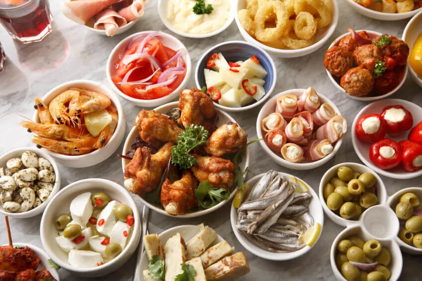 A selection of authentic Spanish tapas dishes including chicken, olives, prawns and fish.