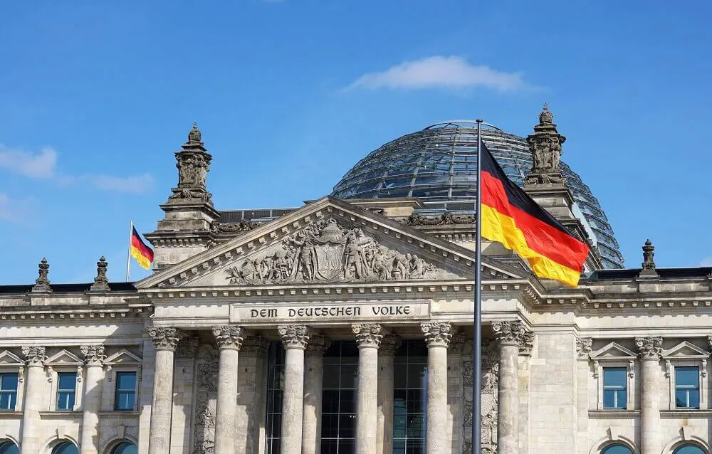 A German flag upon a flagpole outside the Bundestag Building in Berlin, Germany.