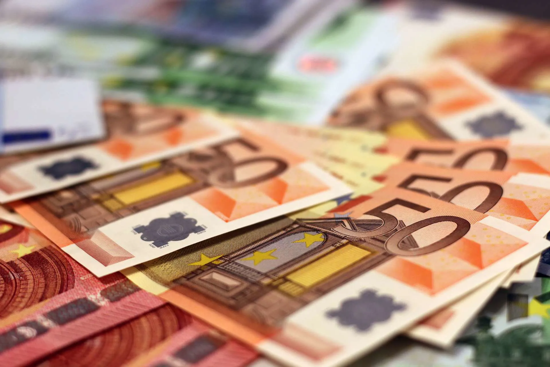 An image of Euro bank notes spread out, focusing on fifty Euro notes.