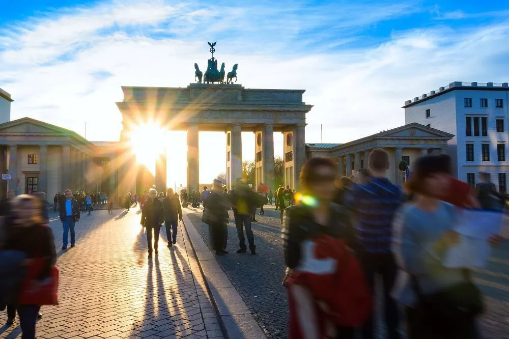 Tourists pass the Brandenberg Gate on a sunny day in Berlin, Germany.