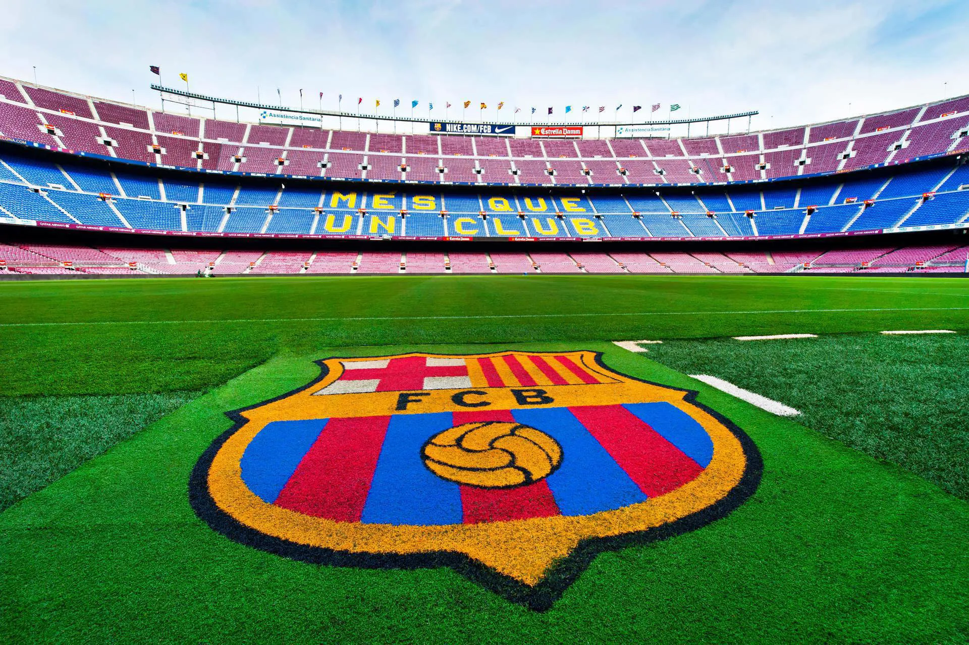 The FC Barcelona logo on the grass at Camp Nou Football Pitch.