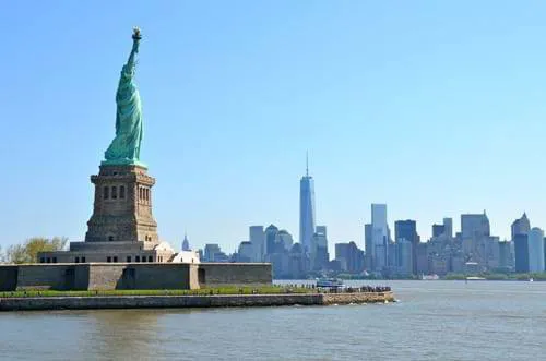 A side profile of the Statue of Liberty, looking onto New York City.