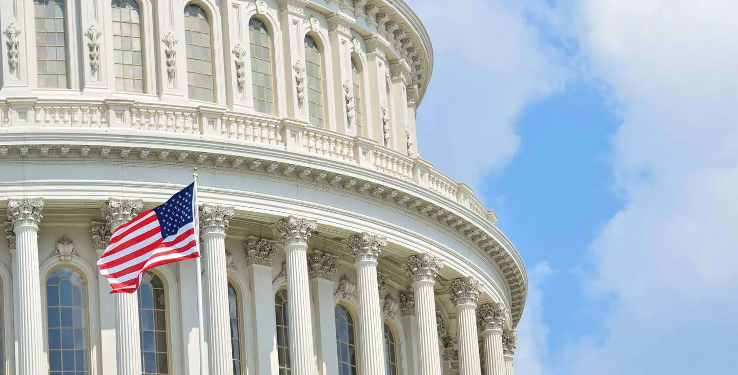 ‘An American flag hangs outside the United States Capitol in Washington, DC.’