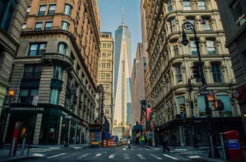Architecture within NYC, lined by a street of buildings and a Starbucks Coffee.