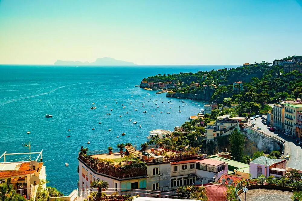 A view of the Bay of Naples as boats ride on the water.