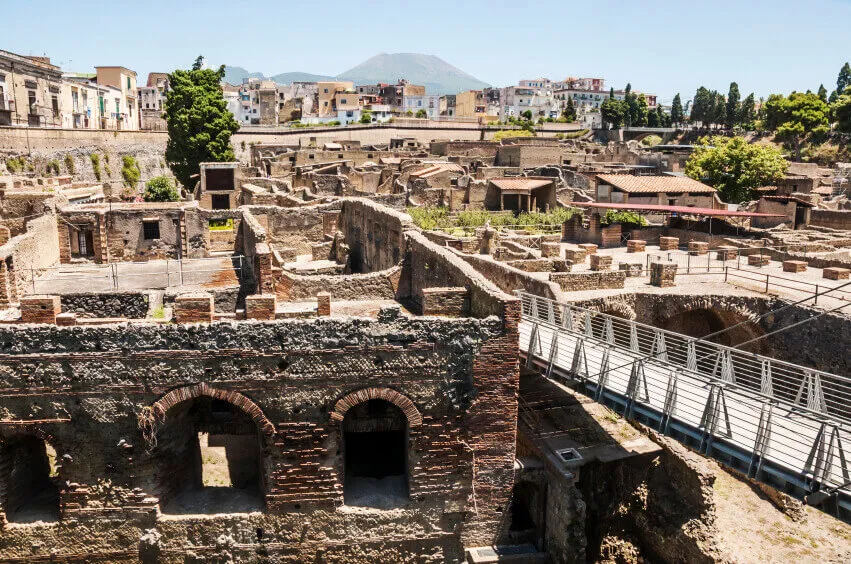 Ancient ruins in the Bay of Naples with a small footbridge running through it.