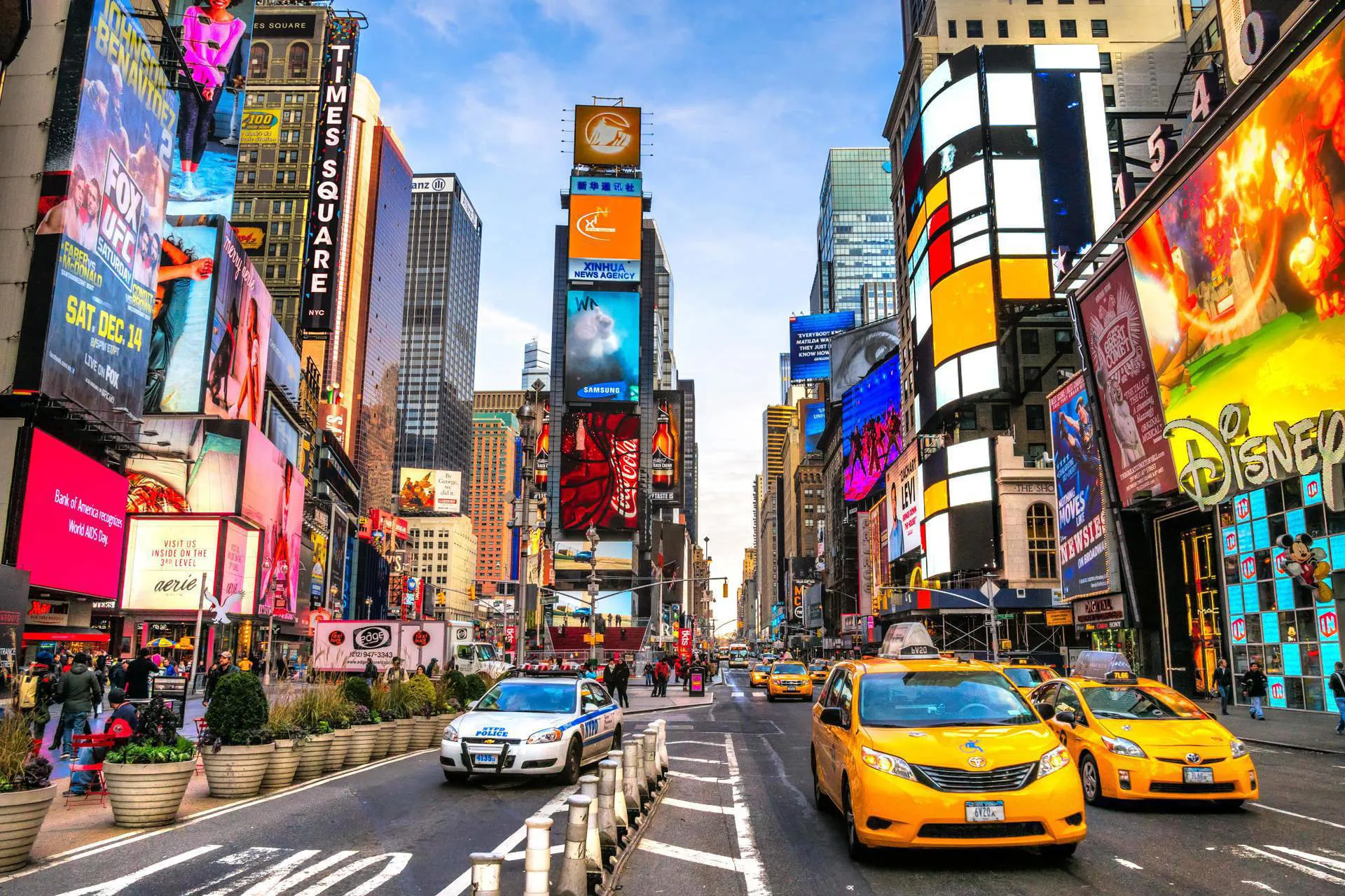 Yellow taxis and a police car on a New York City street.