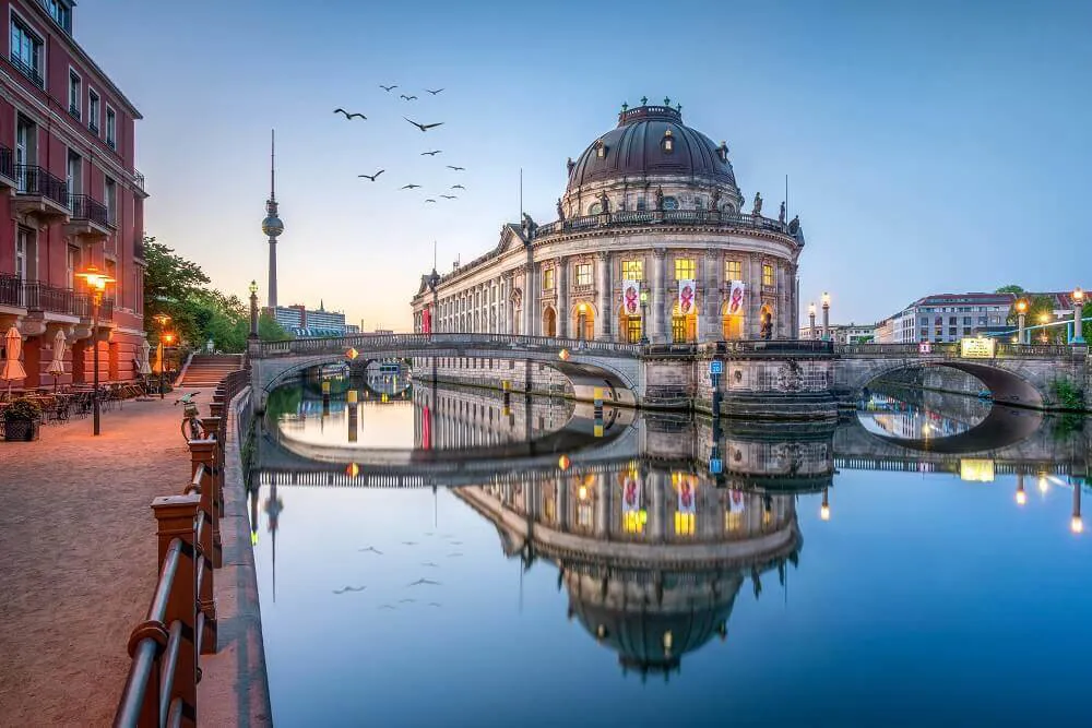 A reflection in a river in Berlin, Germany on a sun set background.