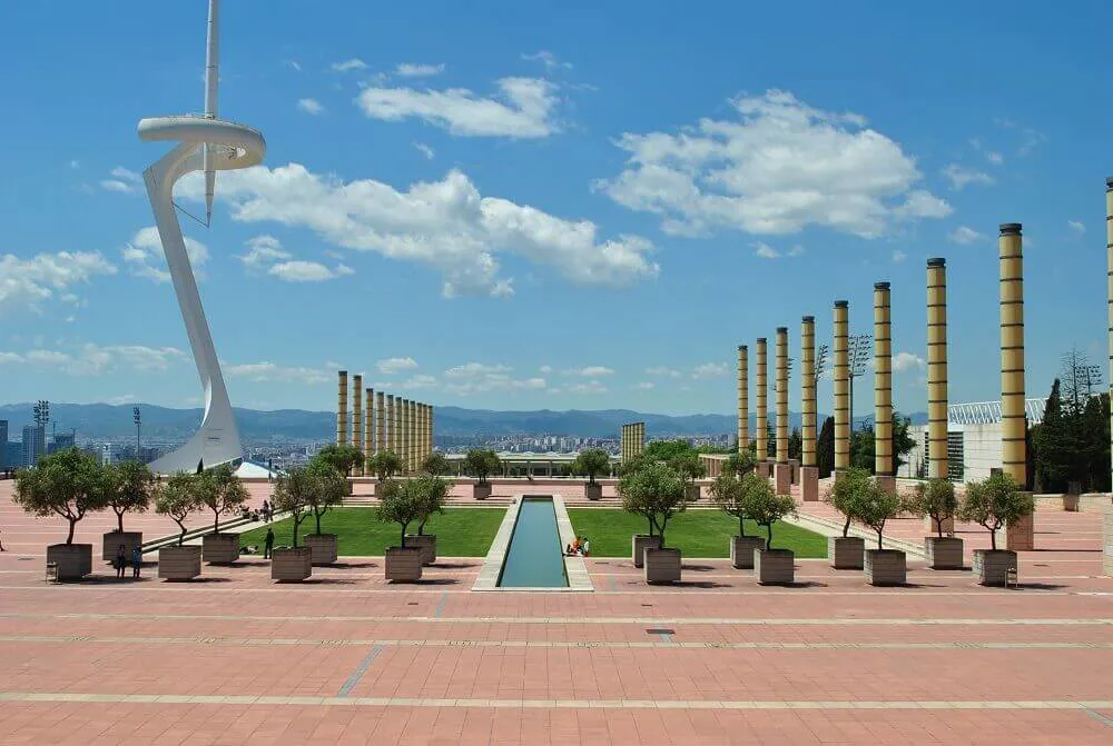A view out to Barcelona city from the Olympic Stadium. Columns line the view and a large white architecture piece is on the left of the view.