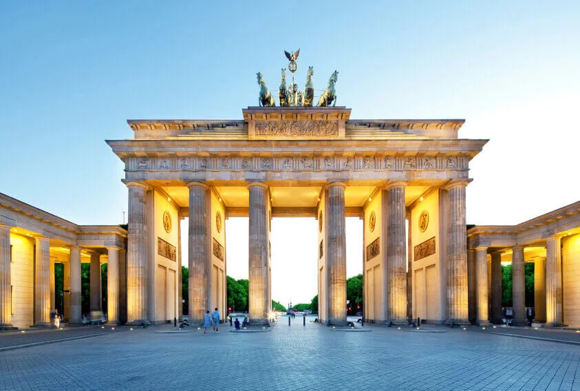 An illuminated Brandenburg Gate on a Berlin evening.