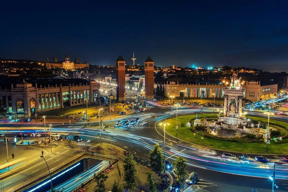 A photo of Barcelona at night, with lots of city lights and cars.